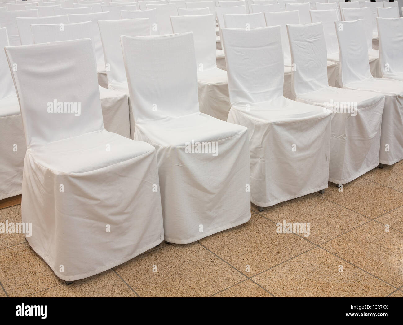 Sedie con tessuto bianco copre in una riga Foto Stock