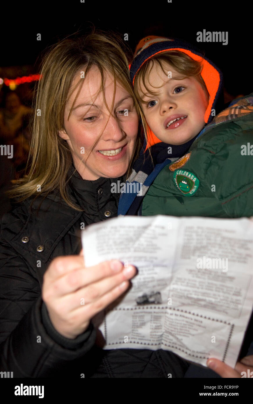 La madre e il bambino che frequentano le comunità locali la christmas carol cantando service 2015, Hindhead, Surrey, Regno Unito. Foto Stock