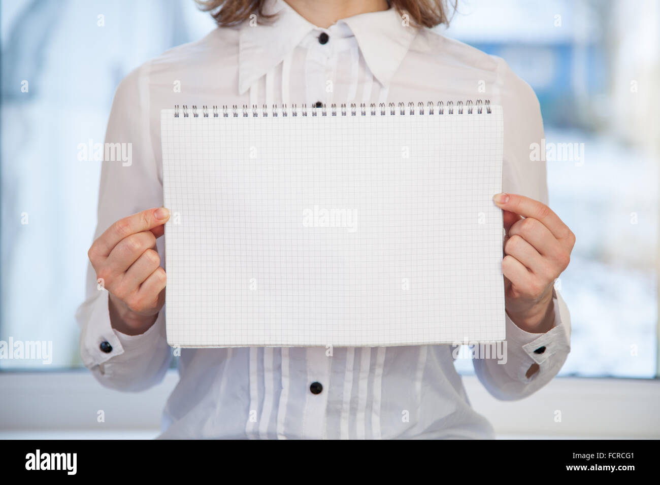 Donna che mantiene l'anello bianco-bound notebook Foto Stock