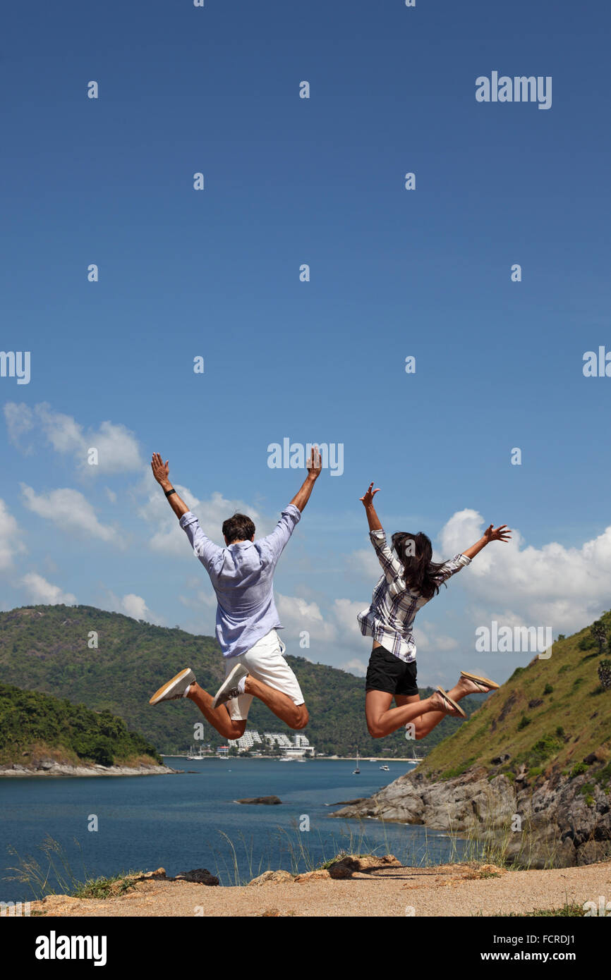 Giovane coppia felice salto e godono di una bella vista sul mare in vacanza Foto Stock