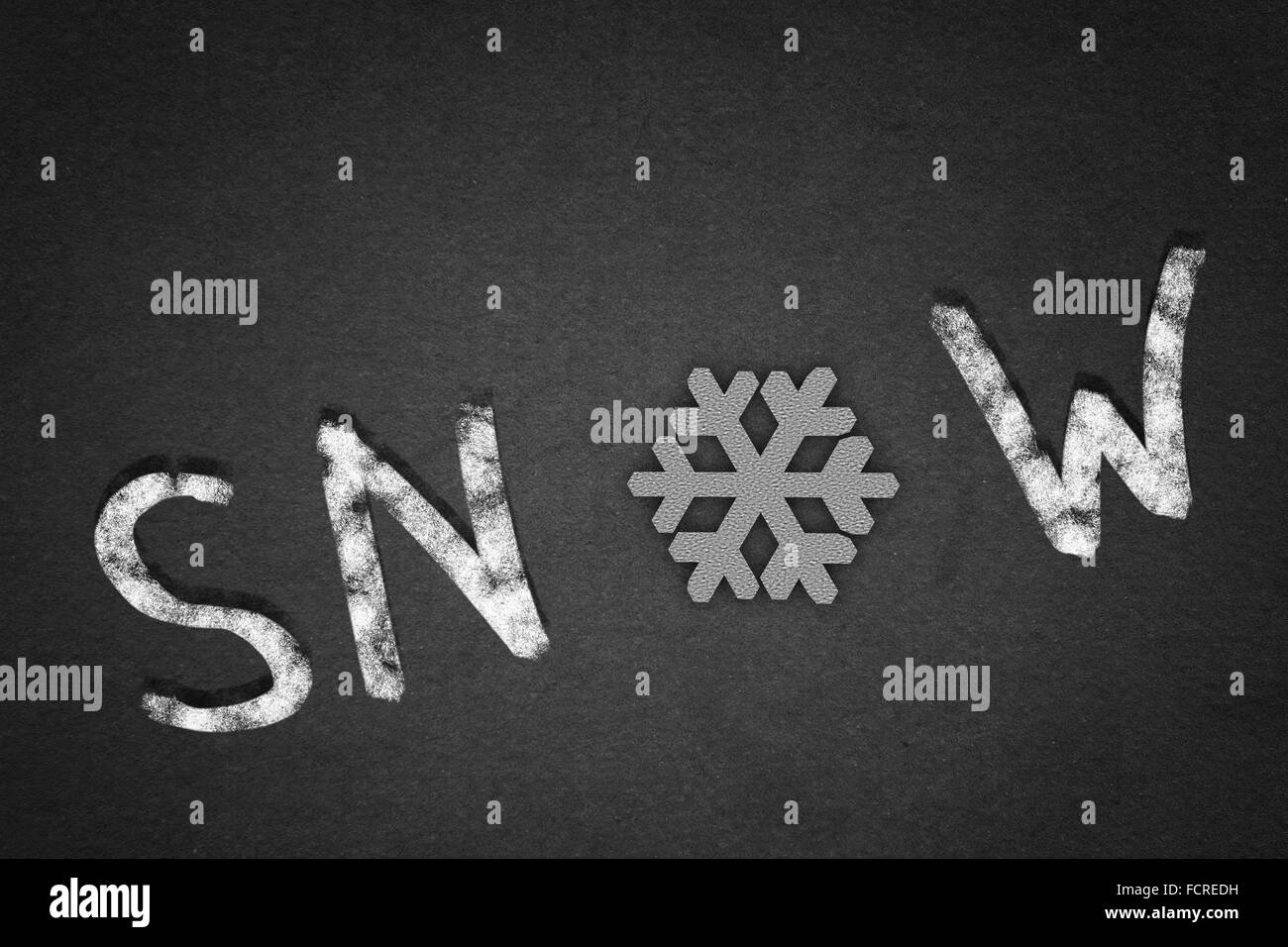 Parola neve su sfondo concreto con il simbolo del fiocco di neve invece della lettera O Foto Stock