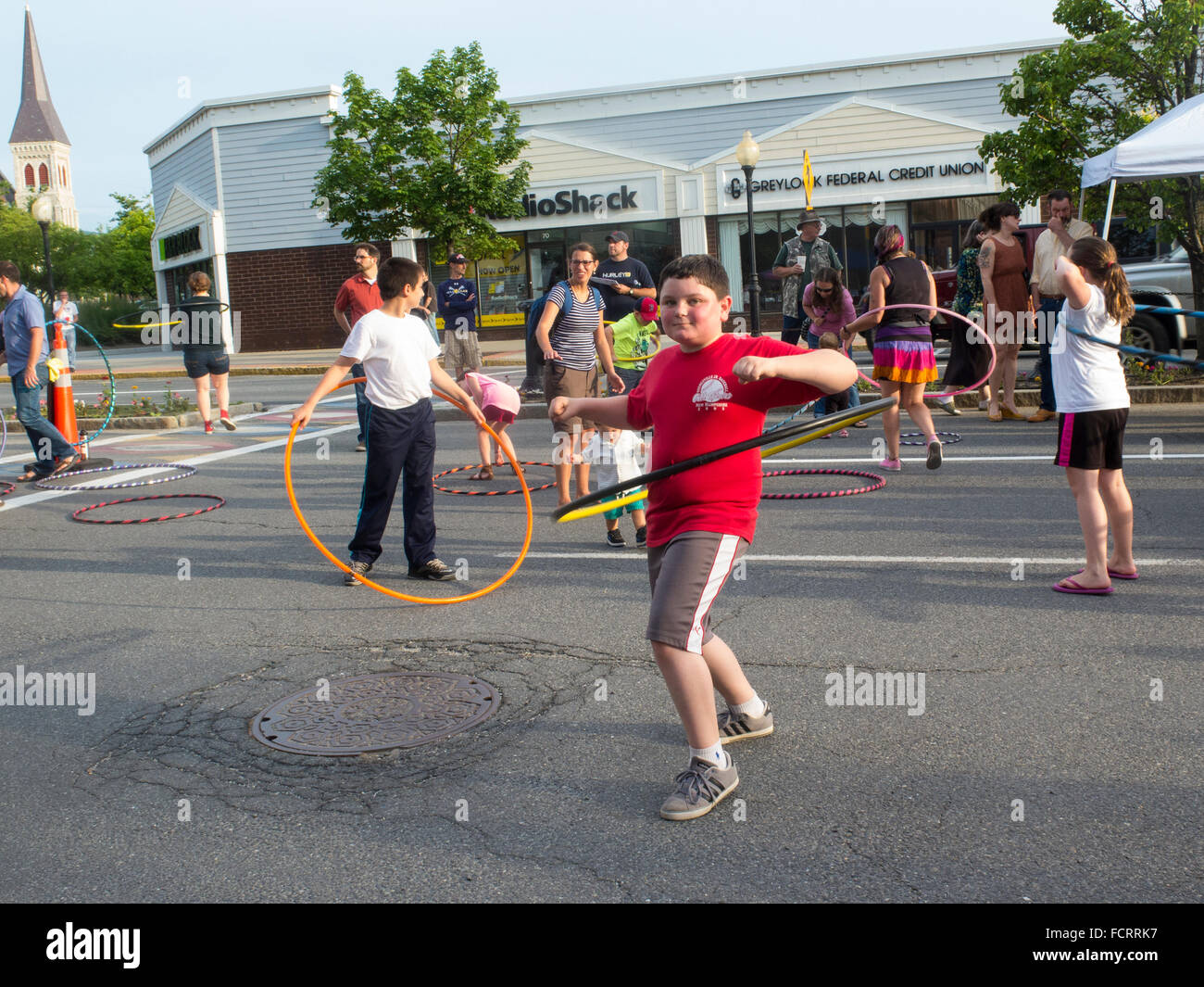 I bambini e gli adulti e provando hula hoops in corrispondenza di un evento artistico di North Adams, Massachusetts. Foto Stock