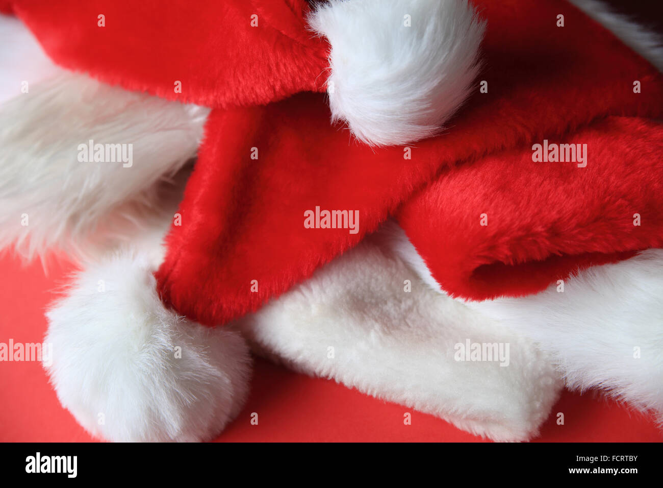 Più Santa Claus cappelli si lancia in una pila Foto Stock