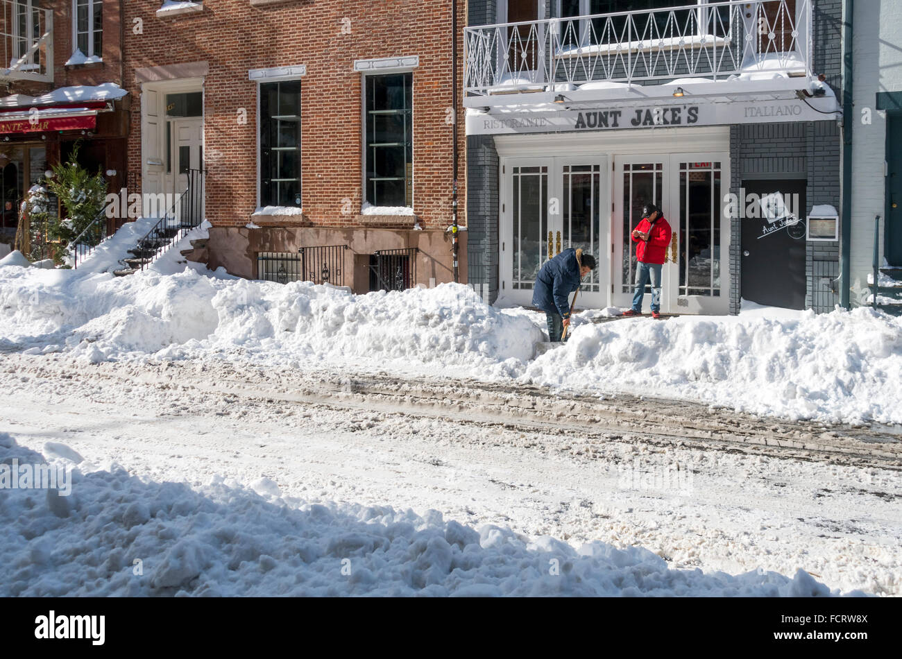 L'uomo spalare la neve per ripulire davanti a zia di Paolo su Mulberry Street in Little Italy in NYC dopo 2016 Jonas Blizzard Foto Stock