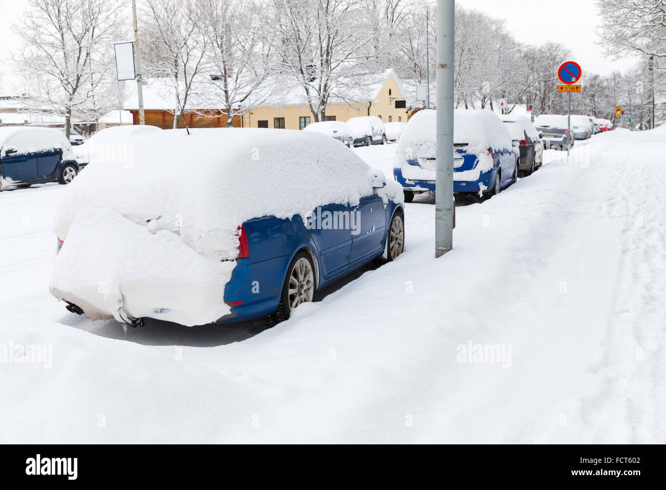 Auto coperti di neve parcheggiato lungo la strada innevata a Turku, in Finlandia Foto Stock