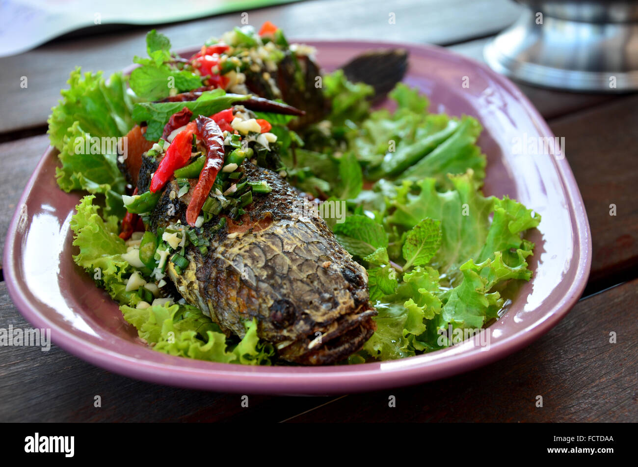 Snake-testa Pesce fritte servite con erbe e salsa piccante al ristorante in Thailandia Foto Stock