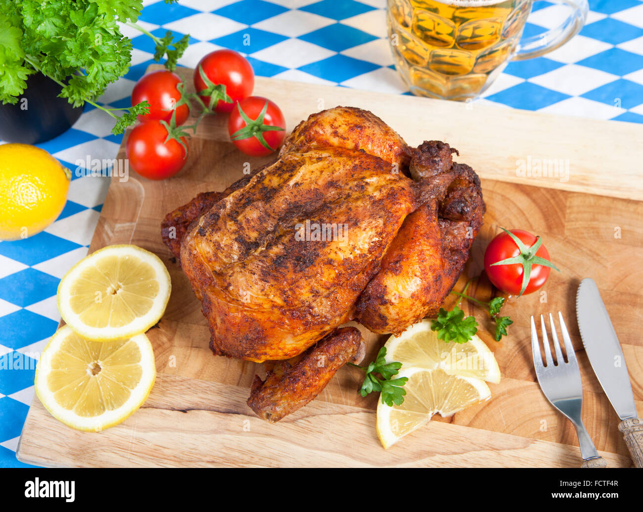Un intero pollo arrosto su un tagliere con contorni Foto Stock