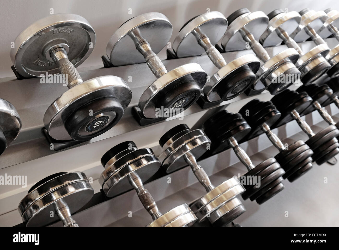 La linea di metallo pesi nella palestra Foto Stock