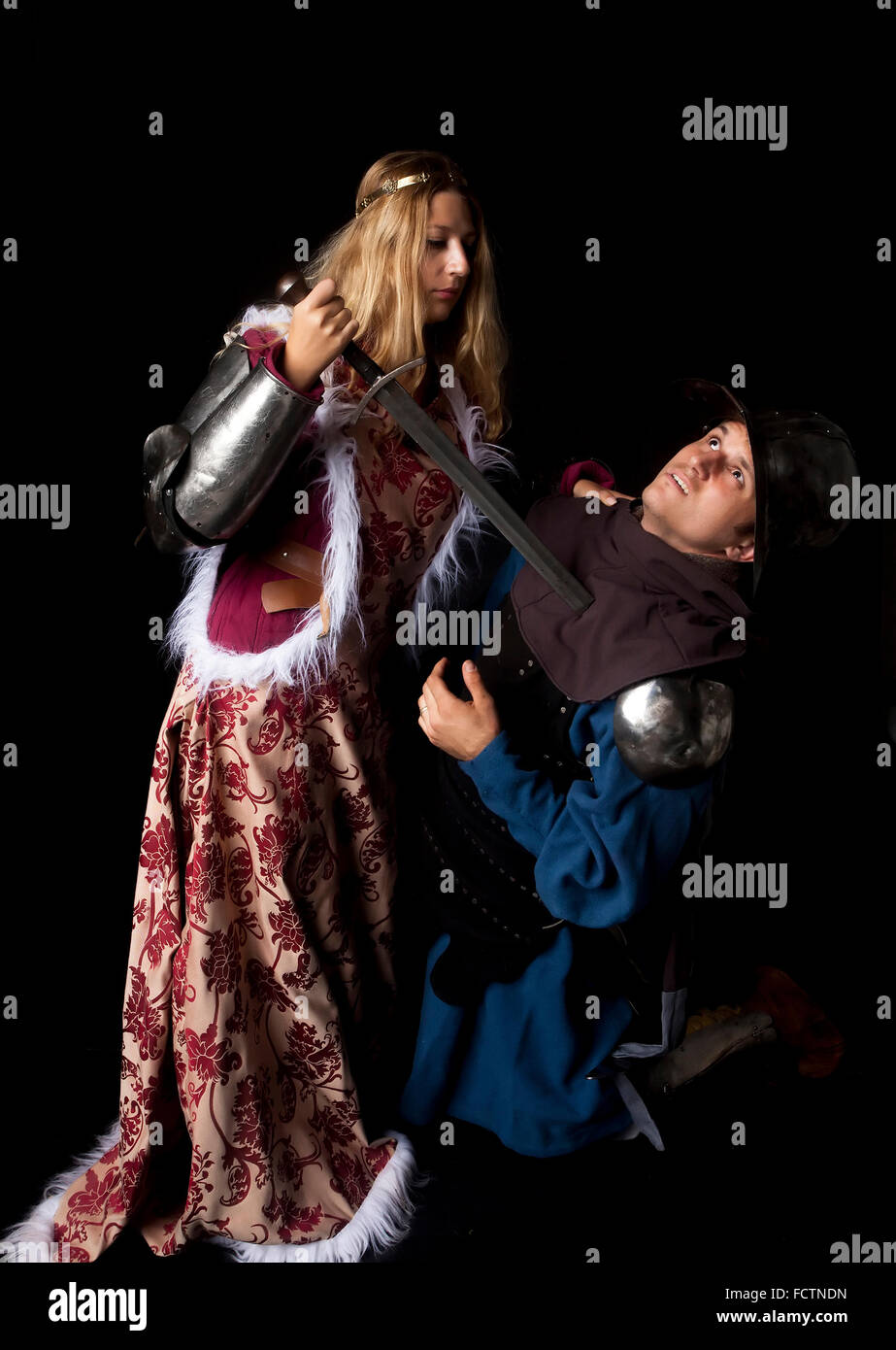 Studio shot di stile medievale in scena con una bella principessa nobile uccidere un cavaliere infido Foto Stock