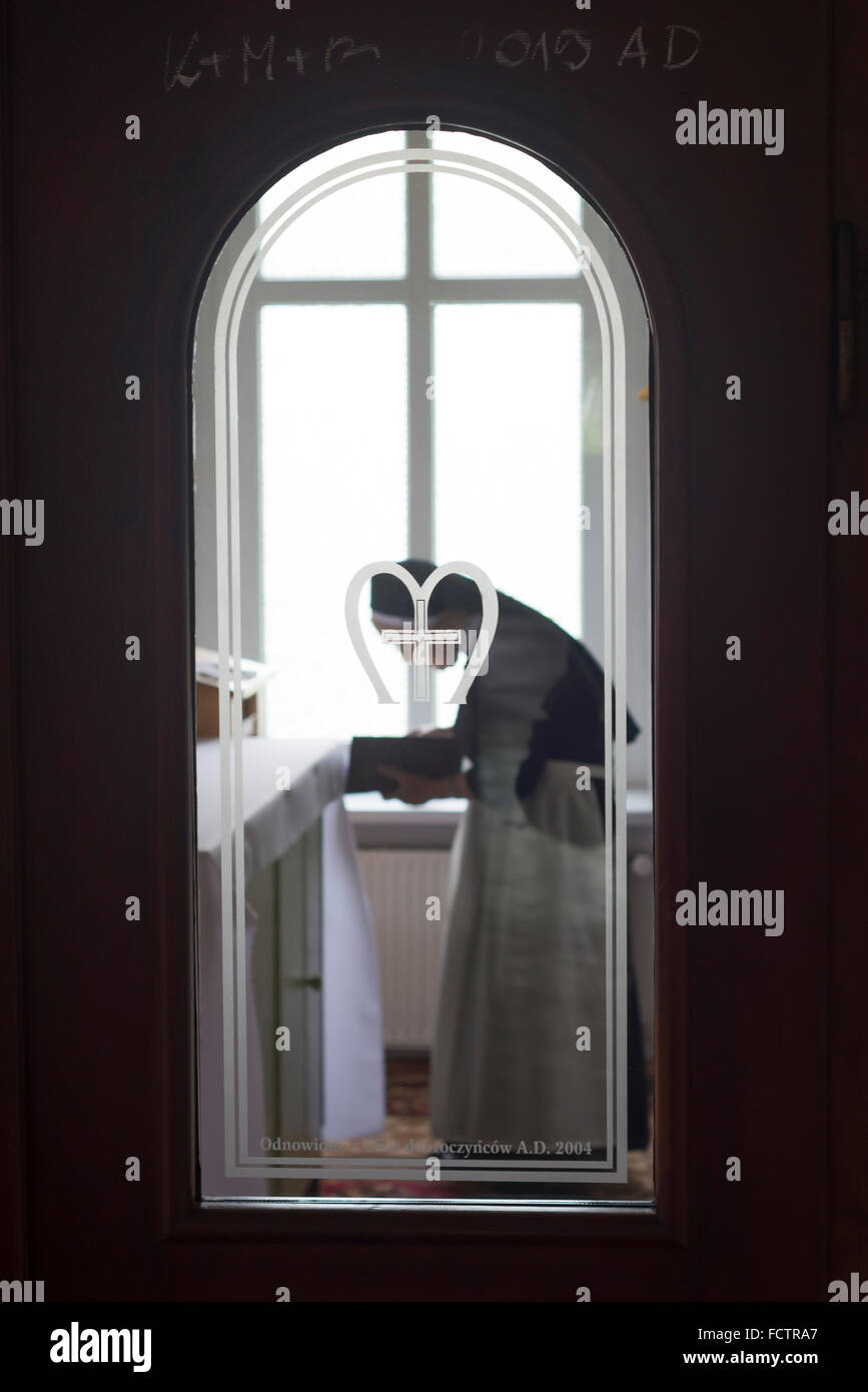 Suora femmina delle Orsoline con un libro in atteggiamento umile in una cappella nel villaggio di Ścinawka Górna a Pola Foto Stock