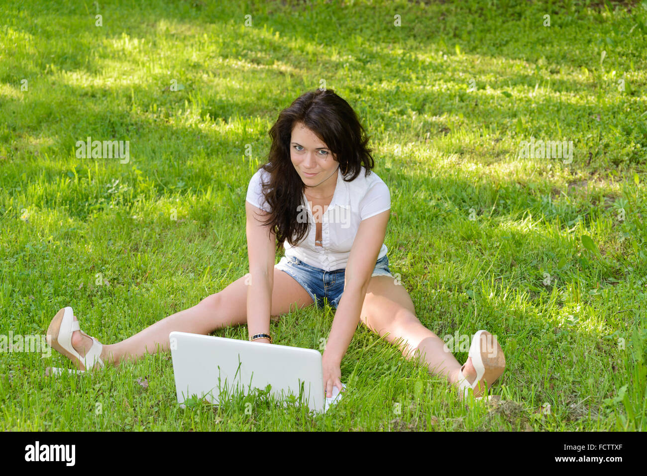 Una studentessa con un laptop nel parco Foto Stock