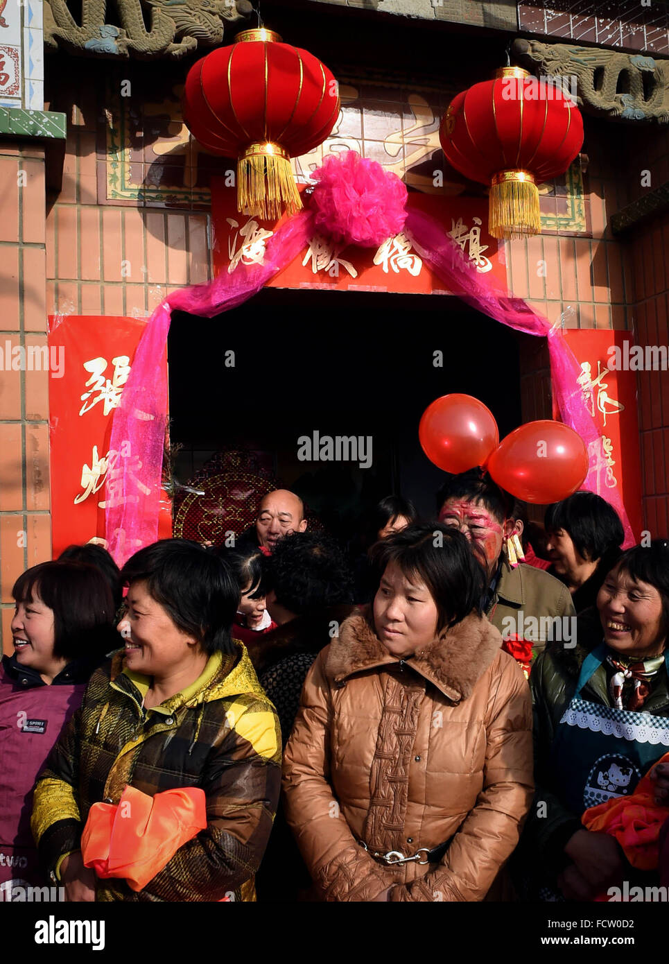 (160125) -- Pechino, 25 gennaio, 2016 (Xinhua) -- la gente in attesa per matrimonio auto accanto a una porta del cortile decorato con lanterne rosse in Nanhedu città di Gongyi City, centrale cinese della Provincia di Henan, Gen 9, 2015. Lanterne in Cina hanno una lunga storia e sono diventati sinonimo di cultura cinese. Anche oggi sono ancora fatto e ci siamo goduti dai cinesi in tutto il mondo. Esse sono state usate come un mezzo di espressione artistica, in termini di funzionalità e design decorazione. Strade cinesi in entrambe le città e le cittadine sono decorate con lanterne rosse durante il festival, specialmente cinese capodanno nuovo anno lunare, Mid-Au Foto Stock