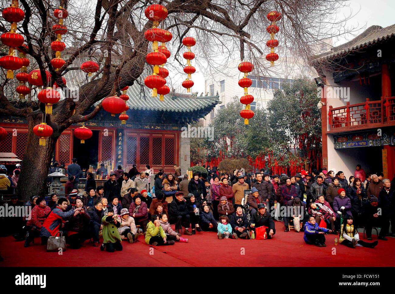 (160125) -- Pechino, 25 gennaio, 2016 (Xinhua) -- persone in piedi sotto lanterne rosse visualizza una performance durante un tempio fair di Zhengzhou, capitale della Cina centrale della Provincia di Henan, 6 febbraio 2011. Lanterne in Cina hanno una lunga storia e sono diventati sinonimo di cultura cinese. Anche oggi sono ancora fatto e ci siamo goduti dai cinesi in tutto il mondo. Esse sono state usate come un mezzo di espressione artistica, in termini di funzionalità e design decorazione. Strade cinesi in entrambe le città e le cittadine sono decorate con lanterne rosse durante il festival, specialmente cinese capodanno nuovo anno lunare, Mid-Autumn Festival Foto Stock