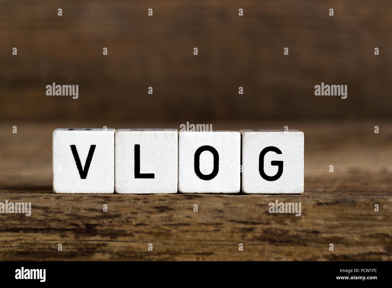 La parola vlog scritto in cubi su sfondo di legno Foto Stock