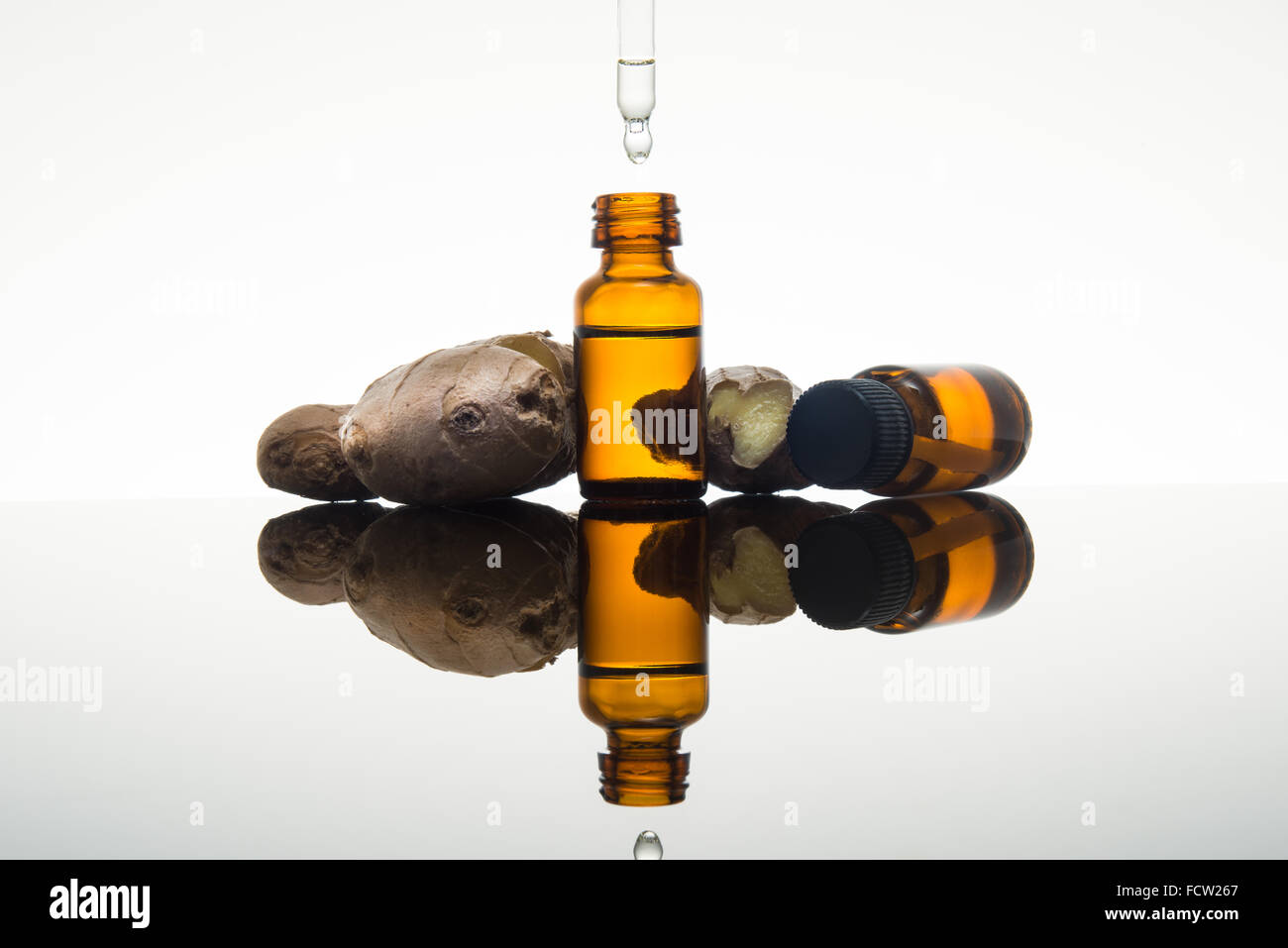 Lo zenzero olio essenziale nel flacone color ambra con zenzero fresco e dropper Foto Stock