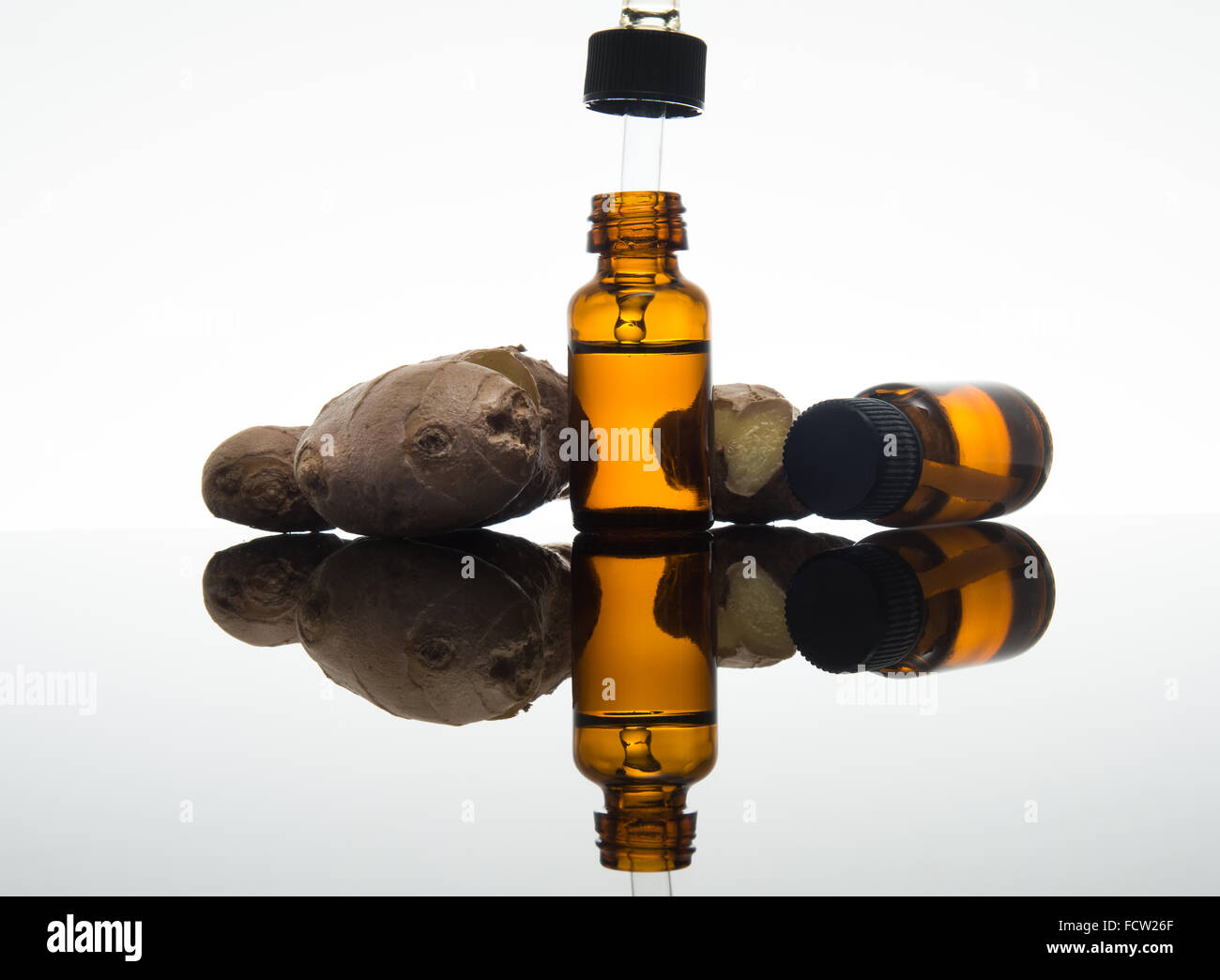 Lo zenzero olio essenziale nel flacone color ambra con zenzero fresco e dropper Foto Stock