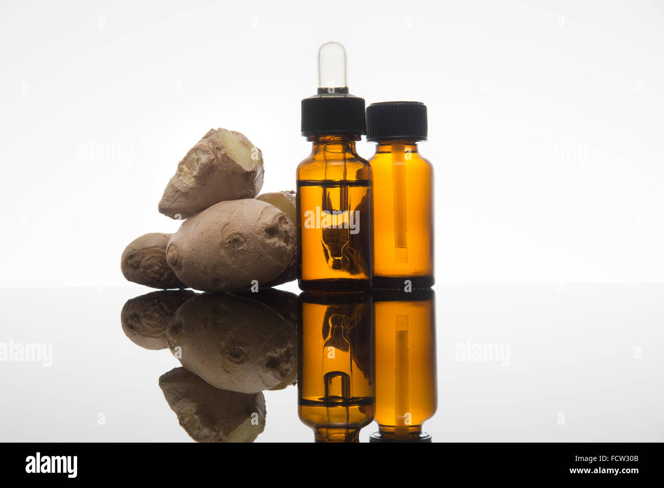 Lo zenzero olio essenziale nel flacone color ambra con zenzero fresco e dropper Foto Stock