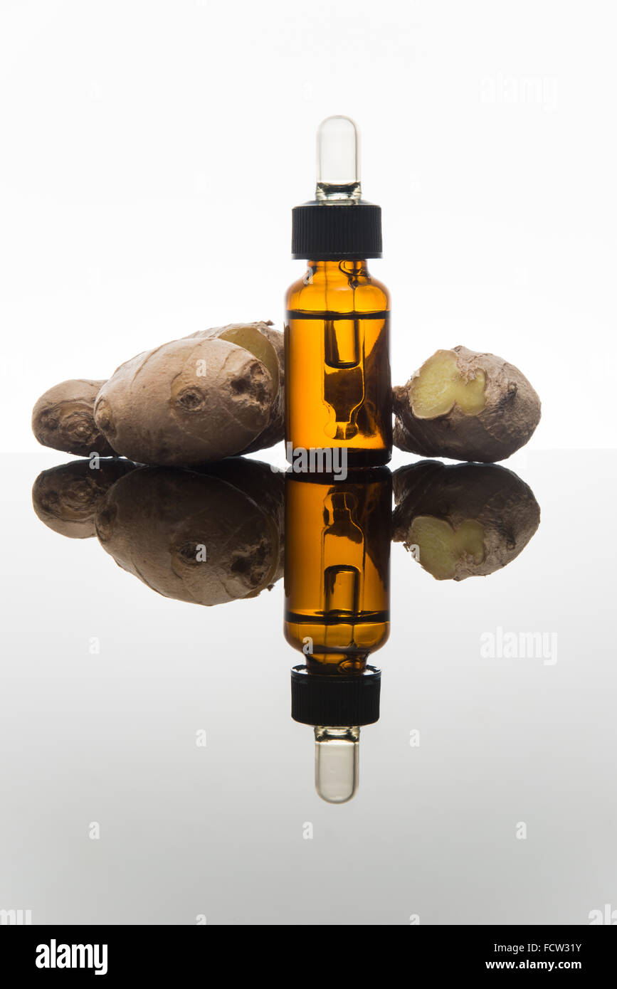 Lo zenzero olio essenziale nel flacone color ambra con zenzero fresco e dropper Foto Stock