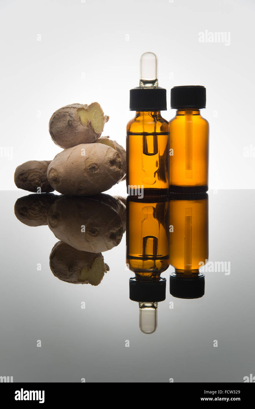Lo zenzero olio essenziale nel flacone color ambra con zenzero fresco e dropper Foto Stock