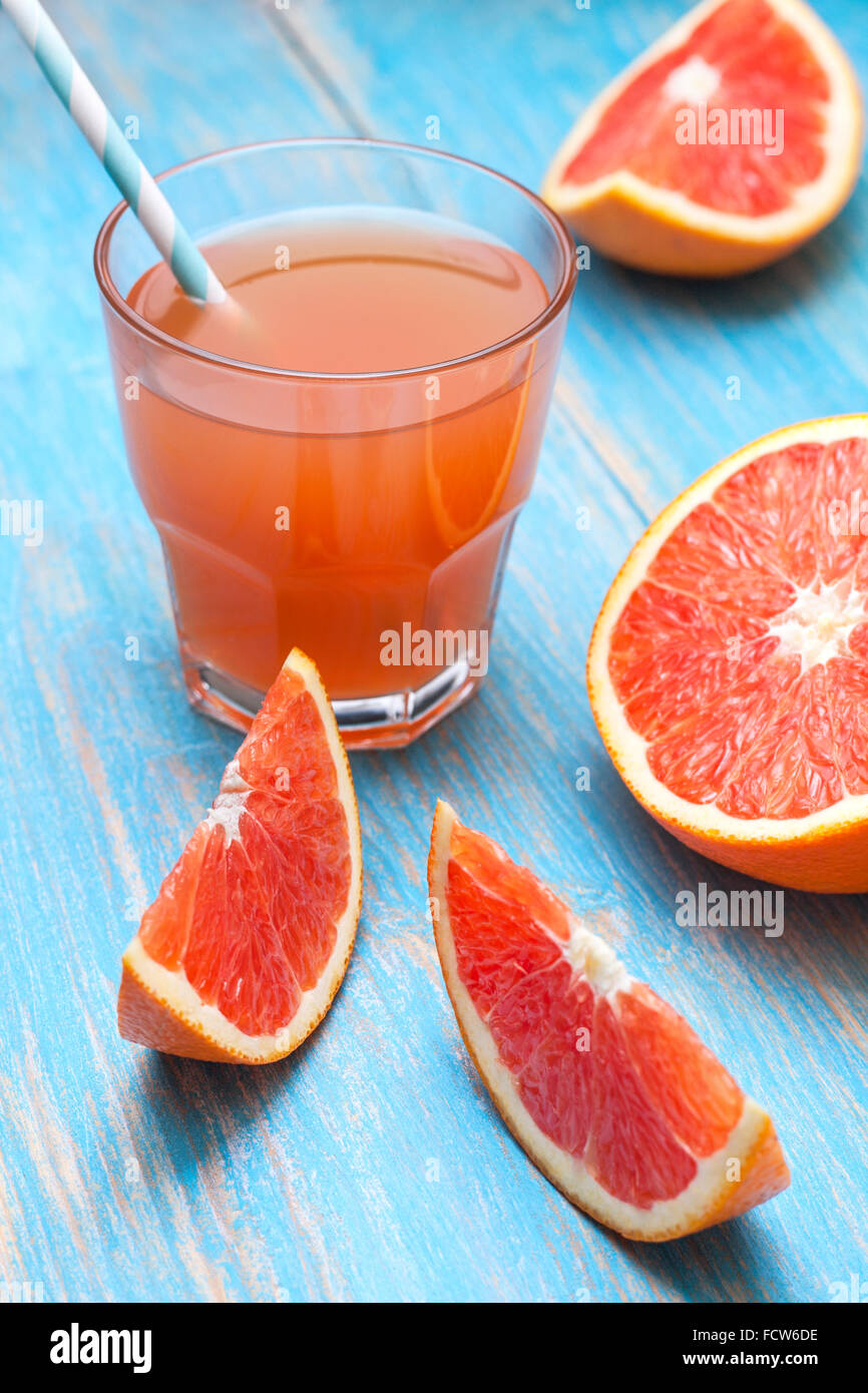 Il succo di pompelmo e succo di pompelmo fresco su un blu sullo sfondo di legno Foto Stock