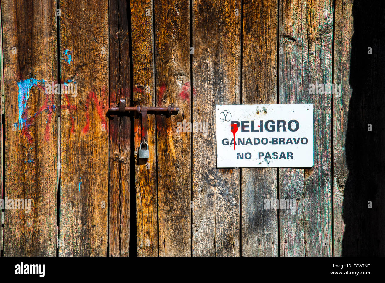 I tori da corrida segnaletica di pericolo su una vecchia porta di legno. Foto Stock