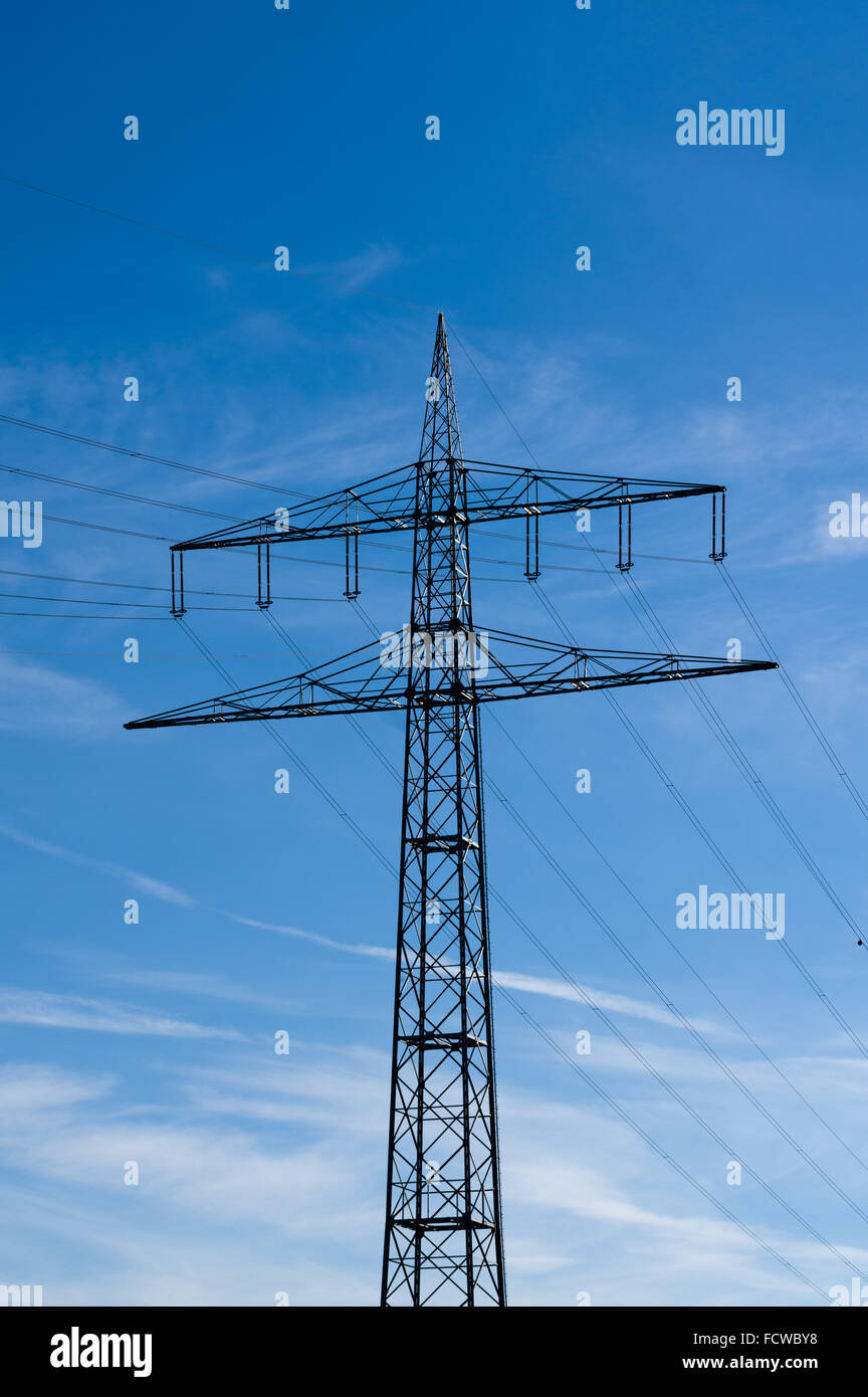 Di elettricità ad alta tensione tralicci contro il cielo blu con nuvole Foto Stock