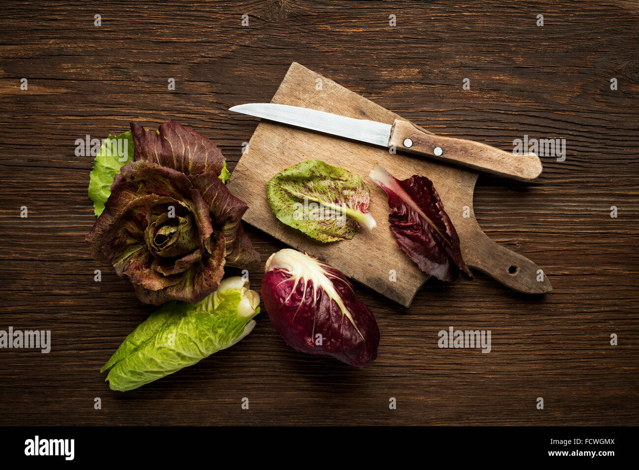 Fresco radicchio misto su un sfondo di legno. Foto Stock