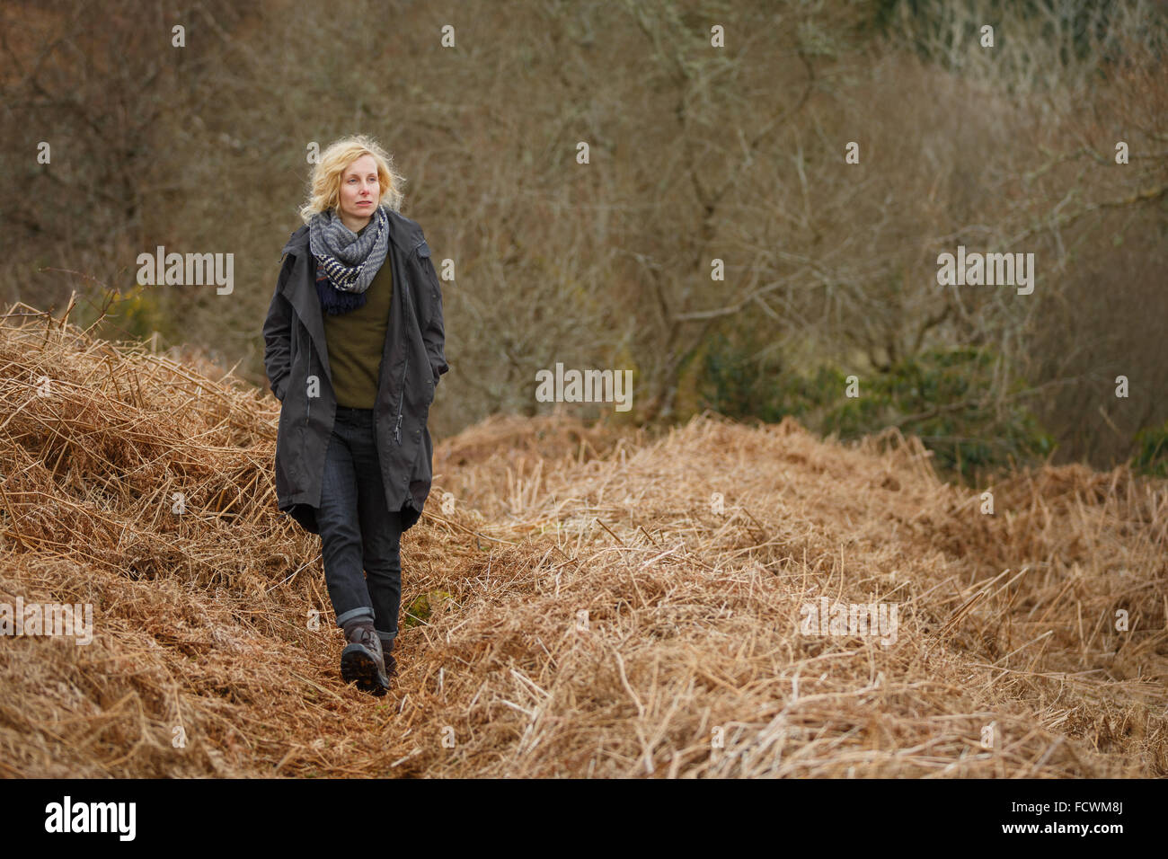 Una donna gli escursionisti a piedi attraverso la natura in Scozia rurale Foto Stock