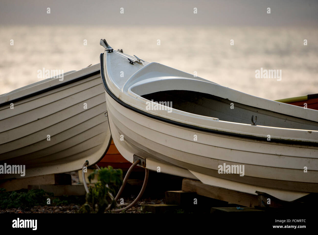 Barche a remi memorizzati sulla riva di un club di angolazione a Hove, Sussex, Regno Unito Foto Stock