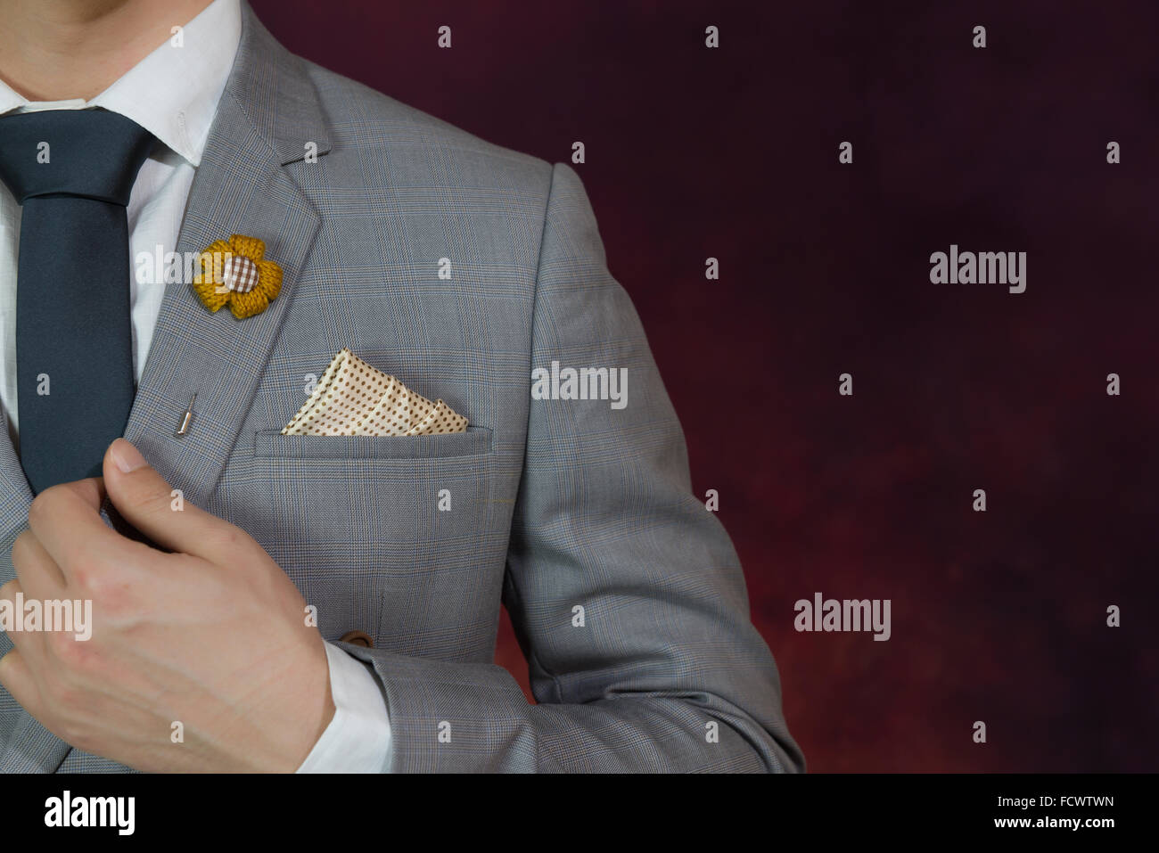 Uomo in abito grigio, plaid texture, cravatta blu, fiore spilla, e la configurazione di punti fazzoletto, close up Foto Stock