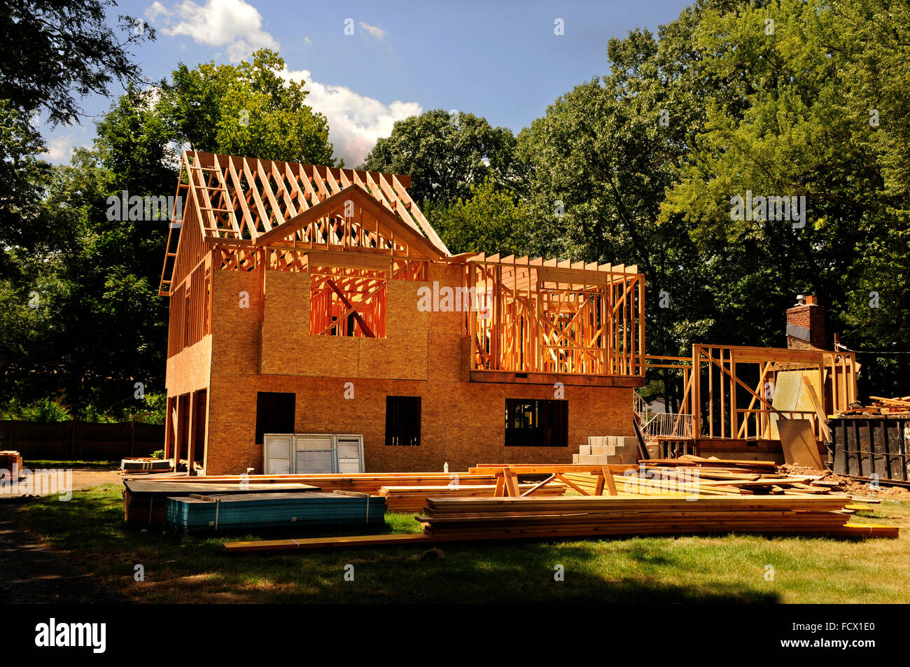 Una casa residenziale in costruzione a metà l'inquadratura e la guaina di protezione Foto Stock