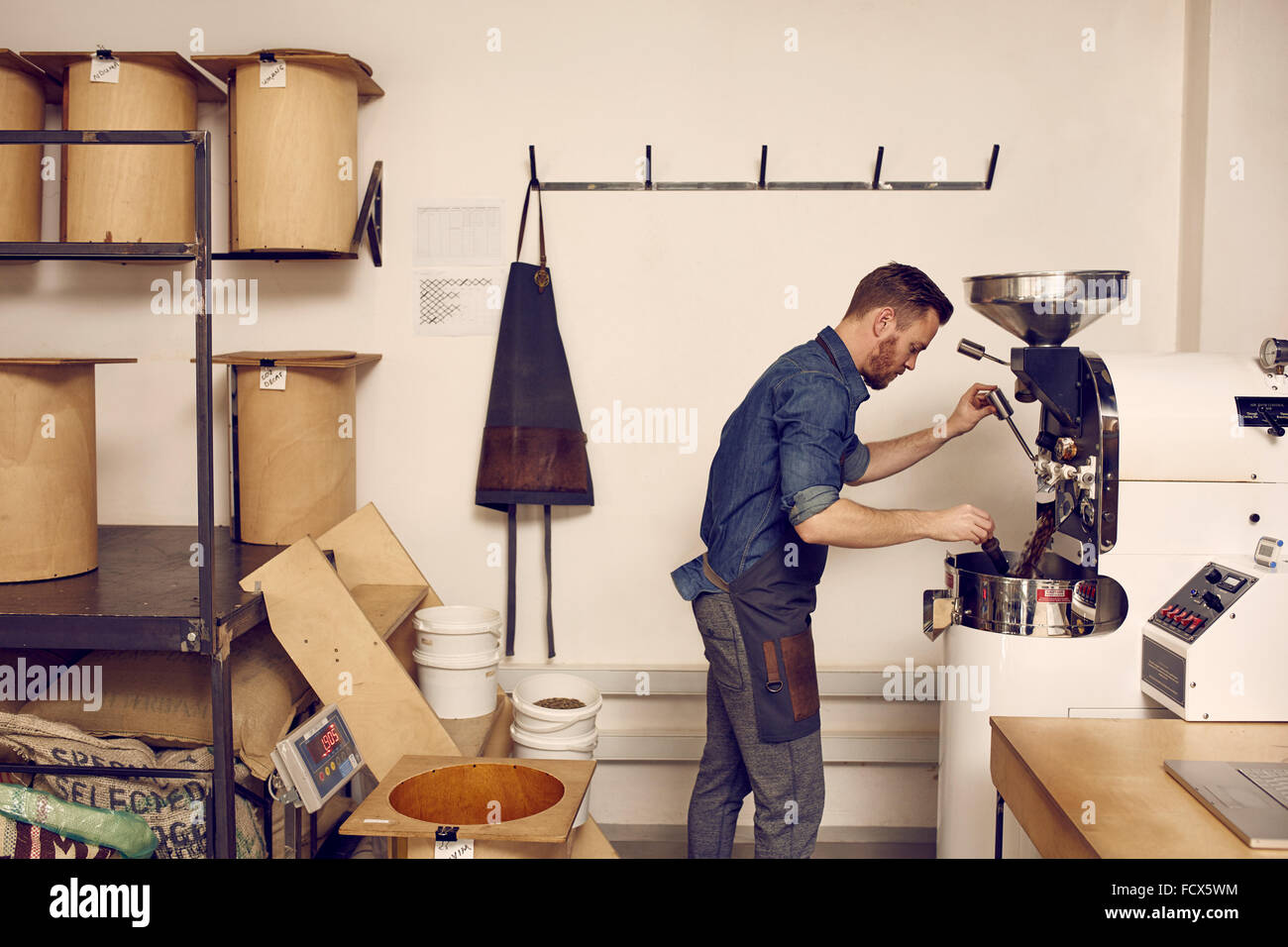 Titolare di azienda operante un moderno Coffee Bean macchina di torrefazione Foto Stock