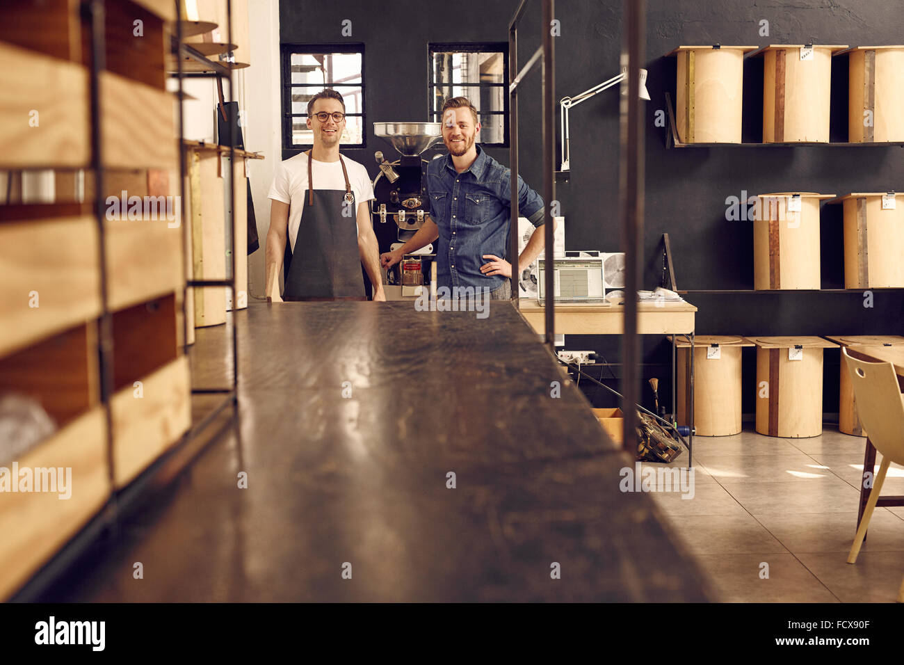 Due hipster uomini sorridenti in un moderno Coffee roastery Foto Stock