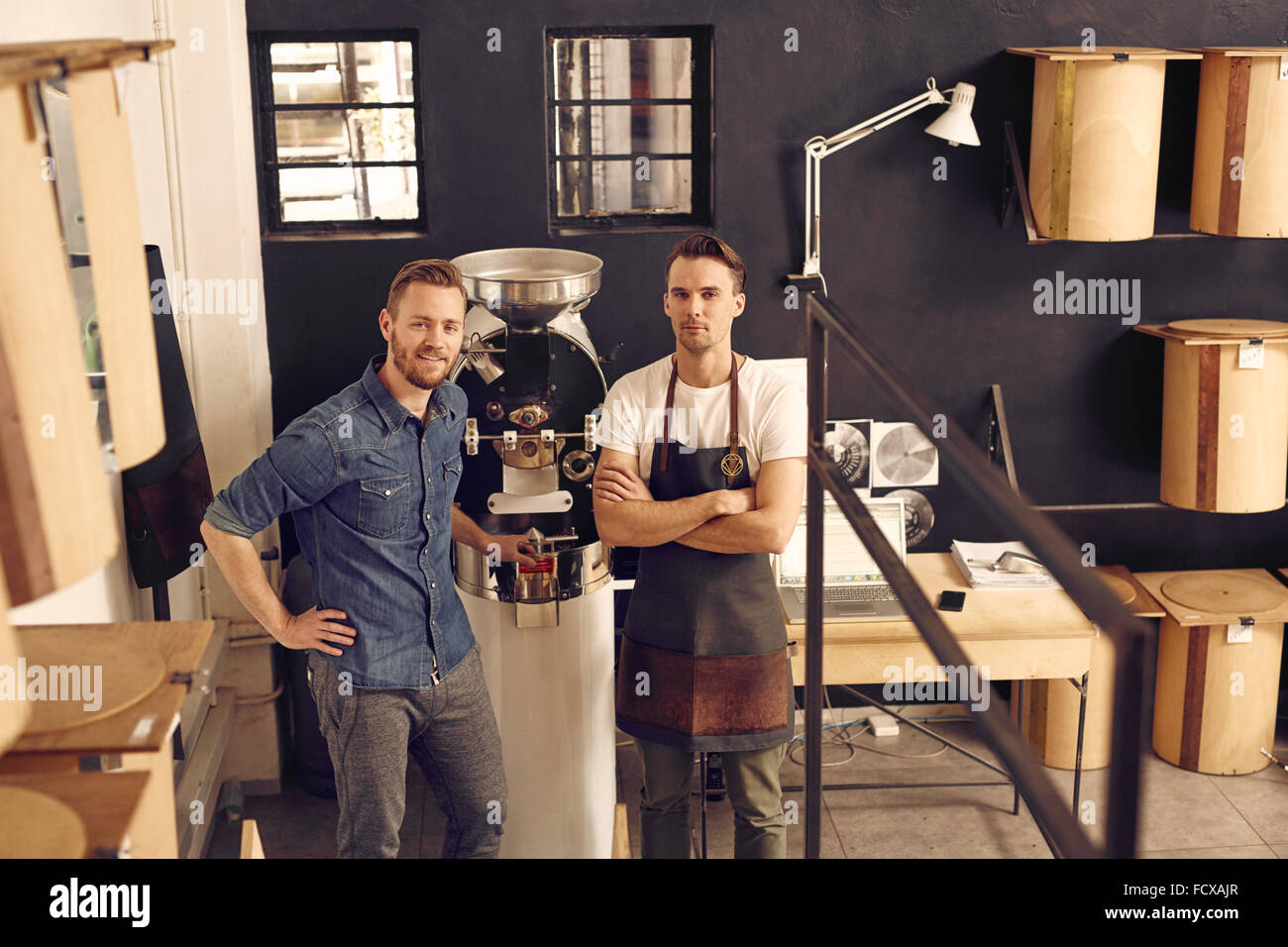Manager e proprietario di un caffè roastery con macchina di torrefazione Foto Stock