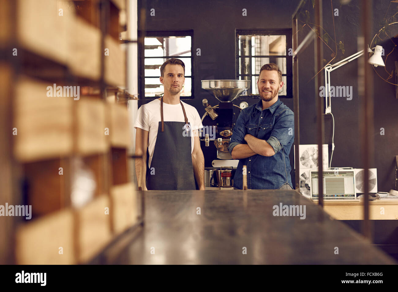 I partner aziendali in un caffè roastery con nuove apparecchiature Foto Stock