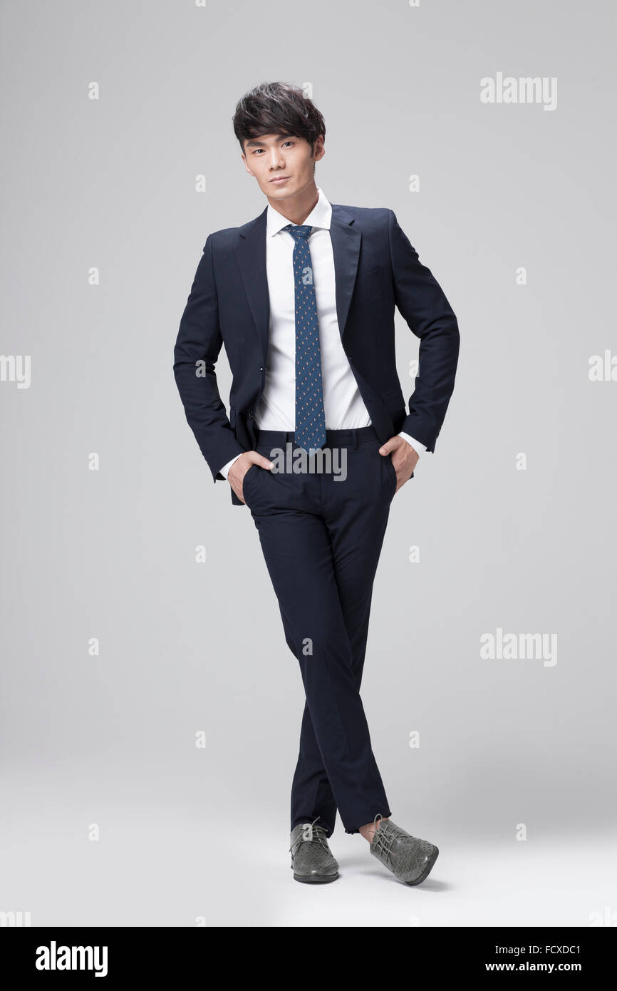 Uomo in abito nero e cravatta in piedi con le mani in tasca dei suoi  pantaloni e lo sguardo in avanti Foto stock - Alamy