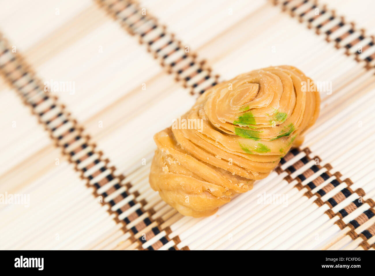 Ottimo curry puff collocato sul pavimento in bambù. Foto Stock