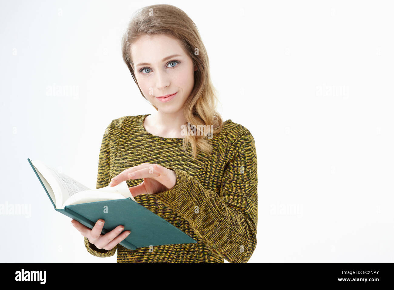 Ritratto di giovane donna sorridente tiene un libro aperto con lo sguardo sul lato anteriore Foto Stock