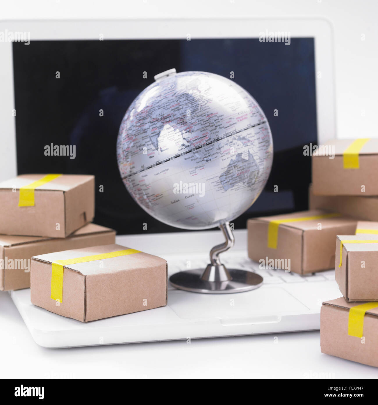 Scatole di consegna e globo con computer notebook, Oltremare acquisto diretto Foto Stock