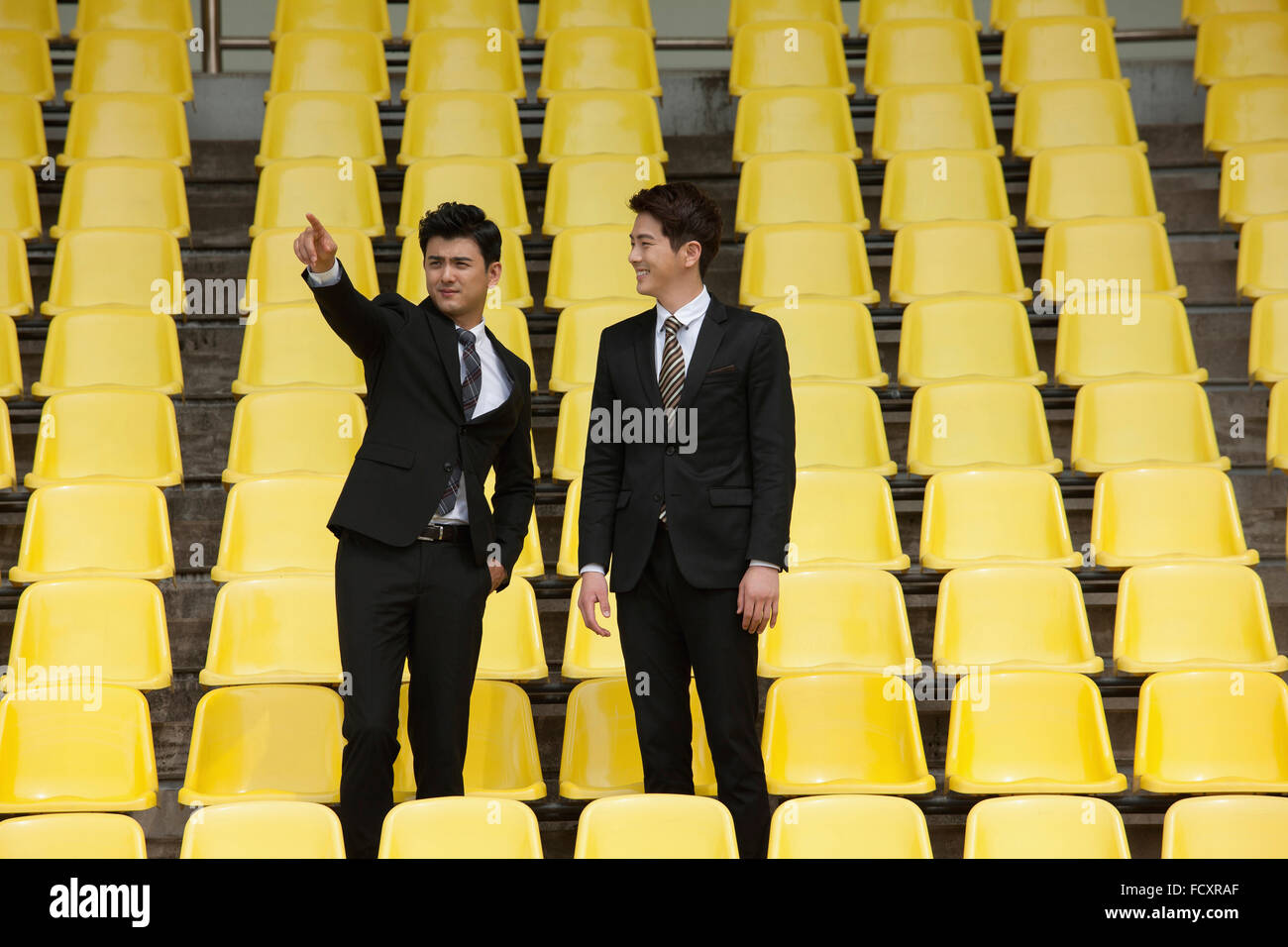 Due proprietari in piedi e puntando a stadium sedi Foto Stock