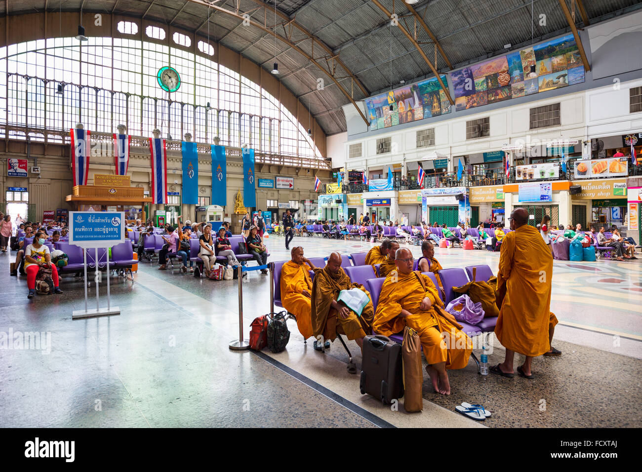 La stazione centrale, i monaci nel salotto di attesa, Hua Lamphong stazione ferroviaria, Chinatown, Bangkok, Thailandia Foto Stock