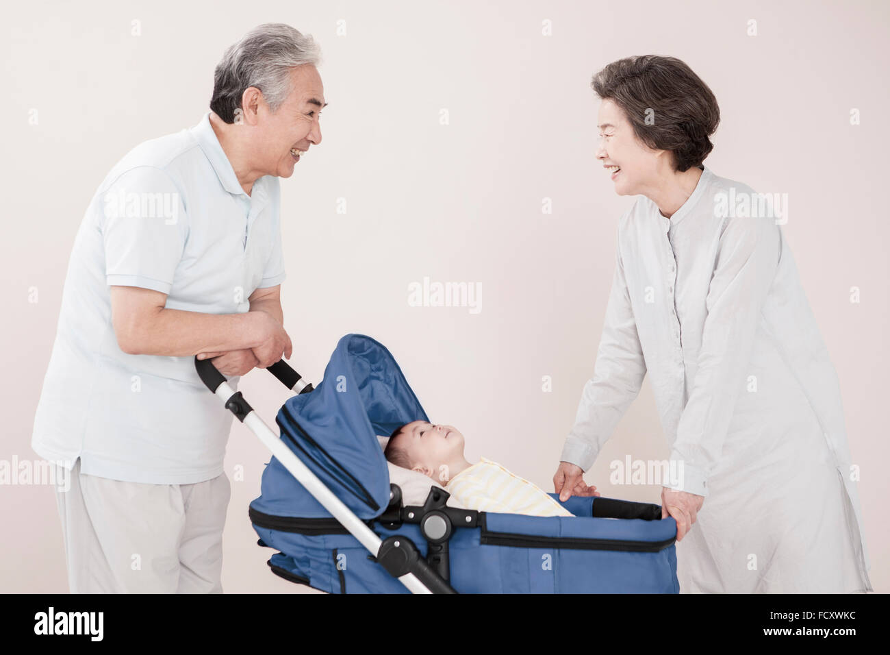 Sorridente vecchio paio di prendersi cura di un bambino Foto Stock