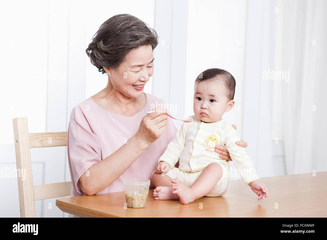 Sorridente vecchia donna allattare il tuo bambino Foto Stock