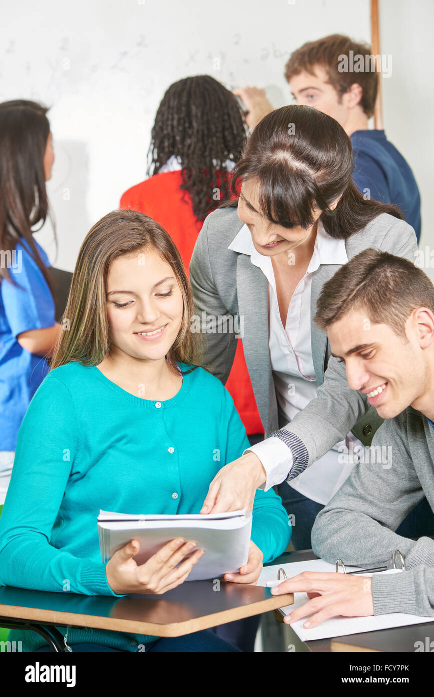 Gli studenti adolescenti studio nella scuola con il loro insegnante di aiuto Foto Stock