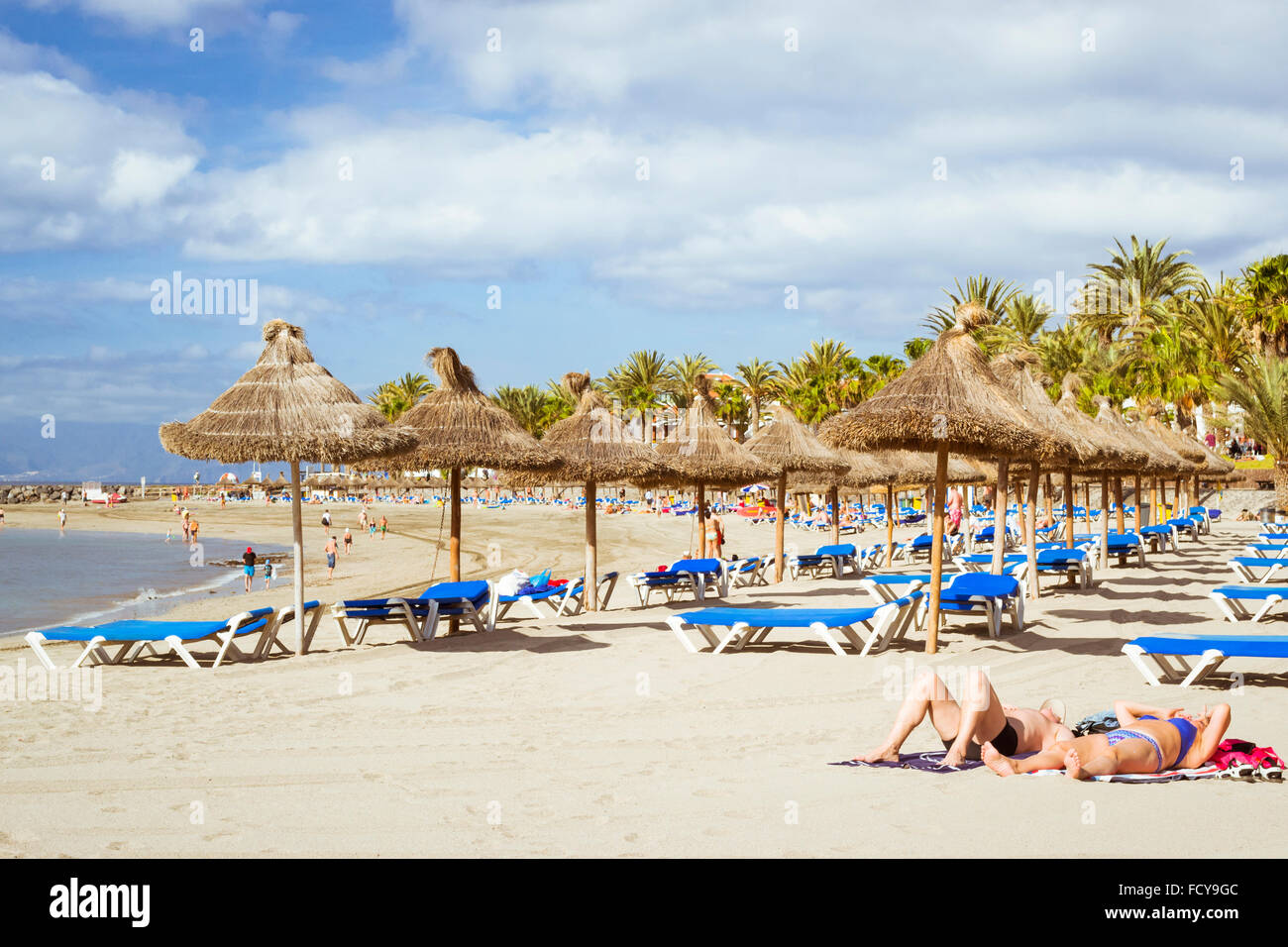 TENERIFE, Spagna - 18 gennaio 2013: Paglia ombrelloni e lettini su Playa de Las Americas, Tenerife, Isole Canarie, Spagna Foto Stock