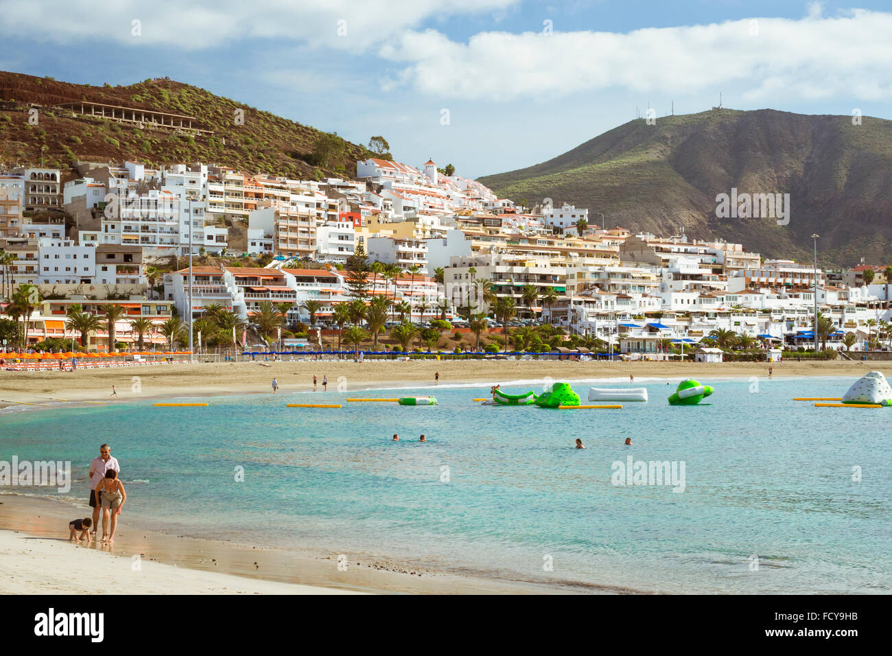 TENERIFE, Spagna - 18 gennaio 2013: spiaggia sabbiosa con blue di ombrelloni e lettini, di Los Cristianos, Tenerife, Isole Canarie, Spagna Foto Stock