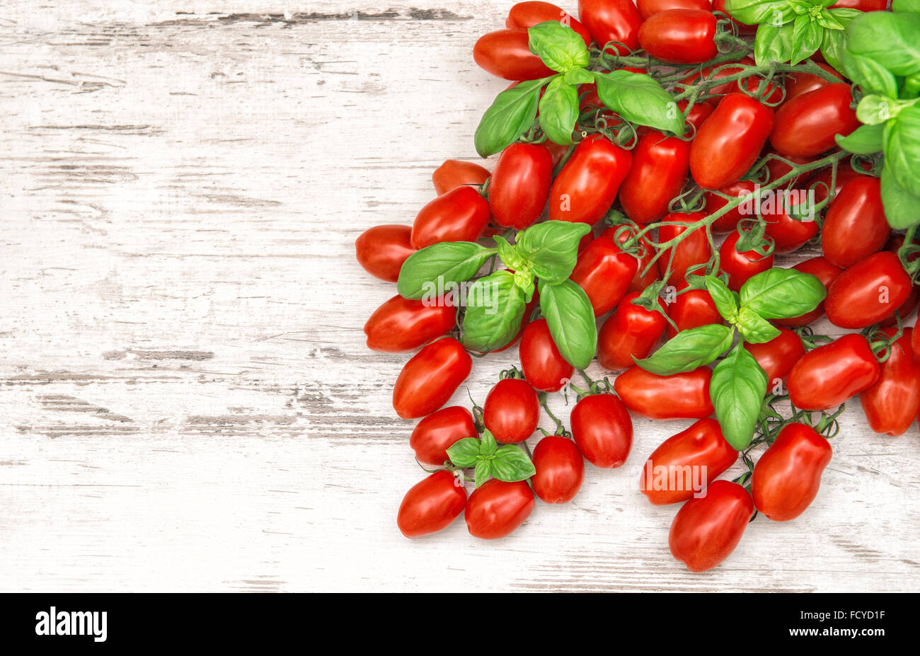 Pomodori ciliegini e le foglie di basilico. Sfondo di cibo Foto Stock