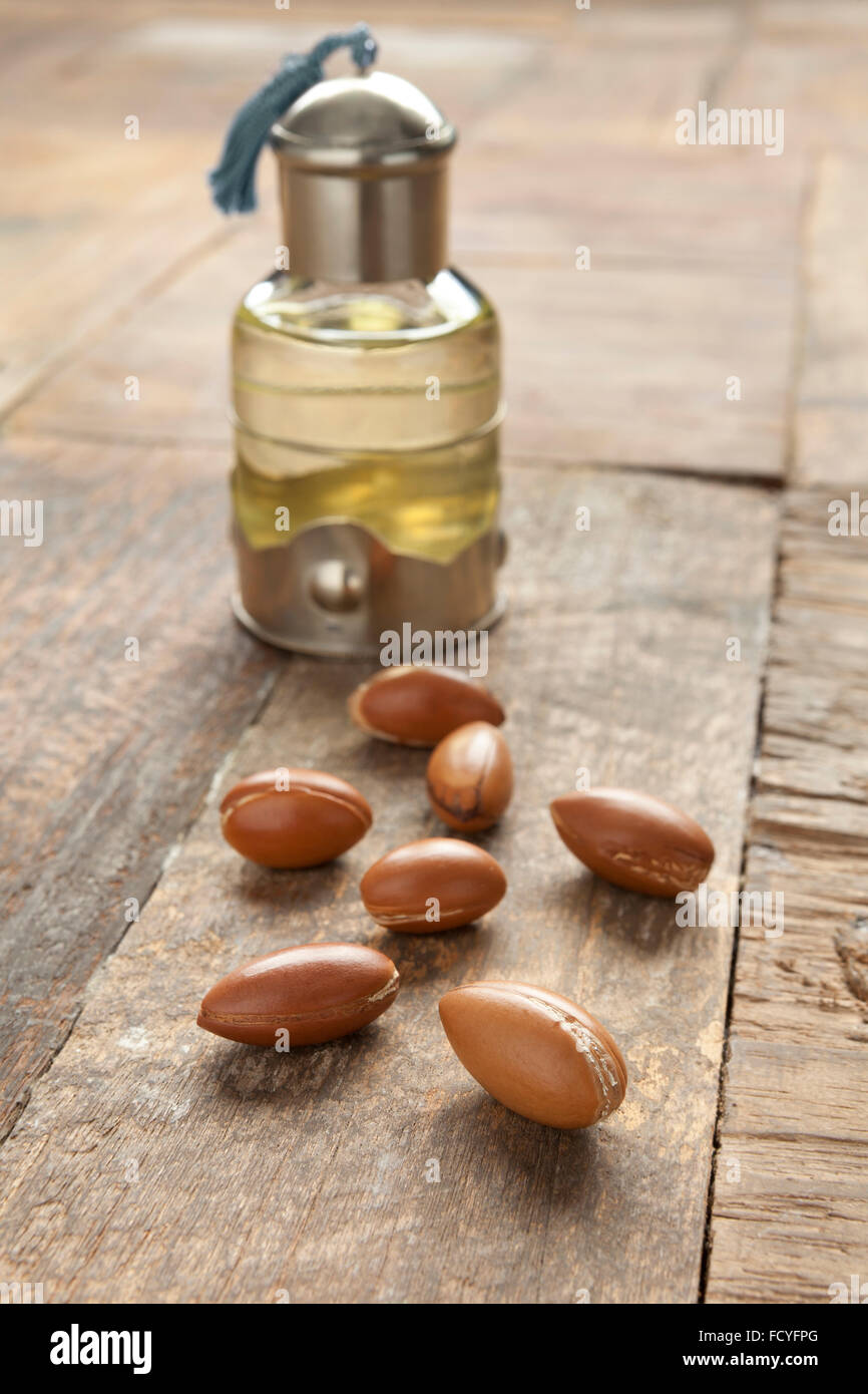 Bottiglia di Marocco olio di argan e i dadi sul tavolo Foto Stock