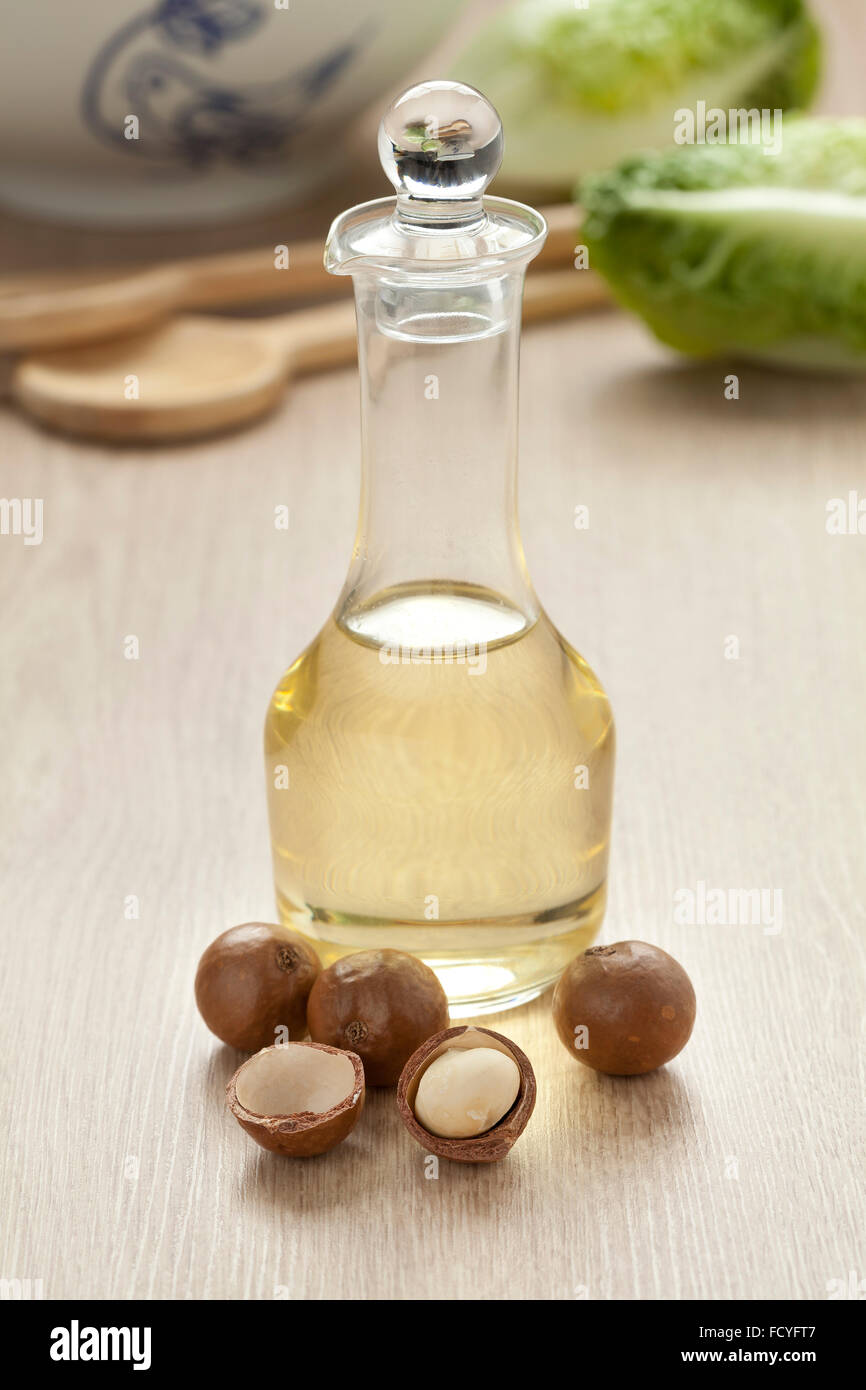 Bottiglia con olio di macadamia e dadi Foto Stock