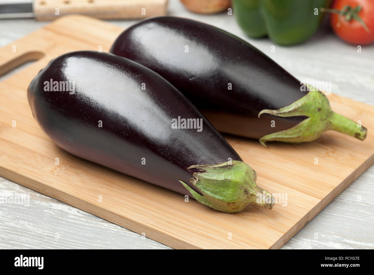 Tutto fresco viola melanzane su un tagliere Foto Stock